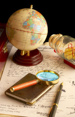 the globe, magnifier with a notebook and the old manuscript.