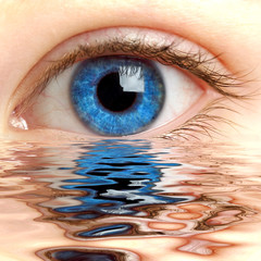 human eye reflected in a surface of water