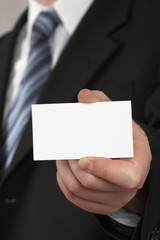 the businessman in a suit and a tie. hand with a white card .