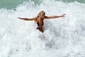 young woman play in waves