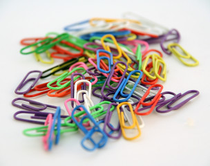 colourful paper clips lying on a white background