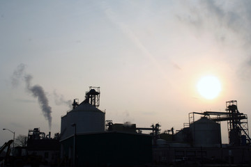 factory silhouette with sun in background