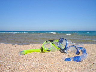snorkel gear on a yellow sandy beach lying near upon coast