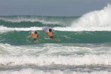jugendliche beim wellenreiten