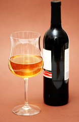 glass of wine and a bottle on biege background