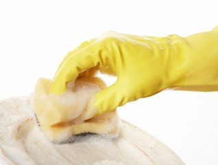 hand in yellow rubber glove with yellow sponge and