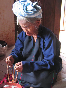 old birman woman praying buddha, myanmar