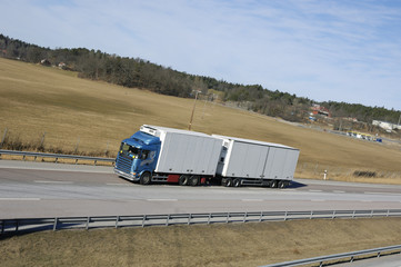 blue/white truck driving on highway