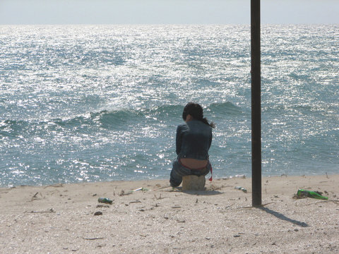 girl alone sits on the seashore