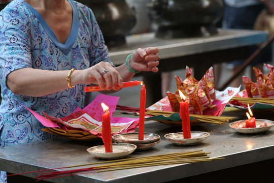 woman in temple lighting a candle