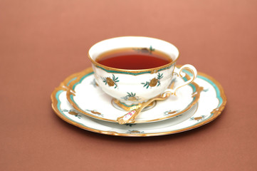 cup of black tea, saucer and spoon