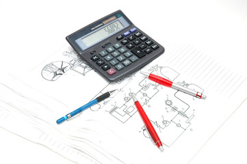 pens and calculator over the engineering drawings