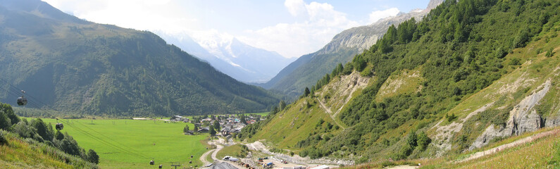 green valley with white mount, balme pass, france, the alps, pan
