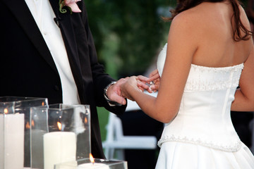 close up bride placing ring on groom