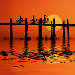 bikers on bridge with sunset