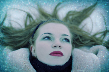 beautiful girl with red lips lying on a snow