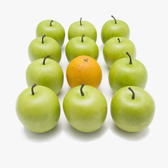 lots of crispy green apples with one orange in between