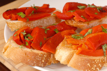 roasted red pepper and basil bruschetta on a white plate