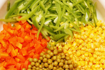 close up of salad with corn, carrots, peppers and peas