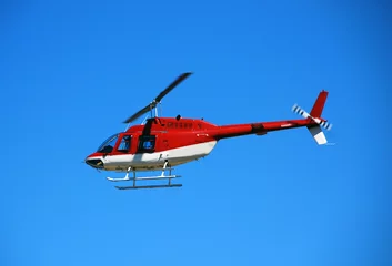 Fotobehang red helicopter in flight bell 206 © icholakov
