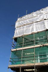 a building covered in scaffolding and tarpaulin.