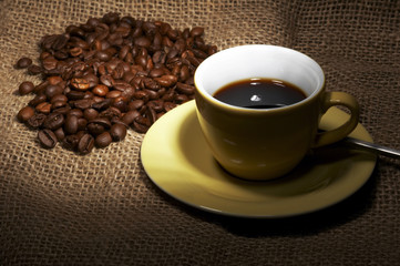 kaffeetasse mit kaffeebohnen auf leinen