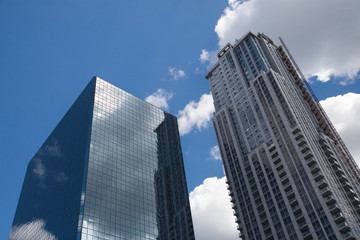 blue sky with clouds shines through office towers
