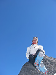femme sur un rocher en tenue de ski