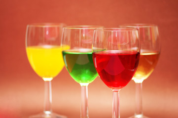 glasses with drinks of various colours on biege ba
