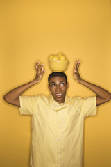 african-american man balancing bowl of lemons on his head.