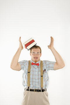 young man with books sliding off head.