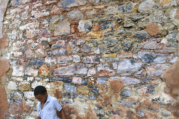 boy to be invisible against a textured stone wall - 2955633