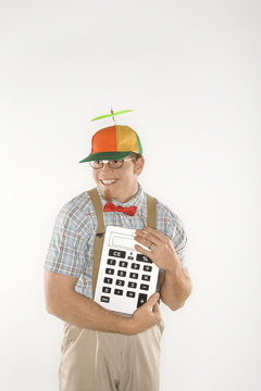 young man dressed like nerd holding large calculator.
