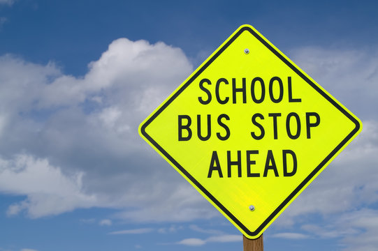 school bus stop ahead sign at right