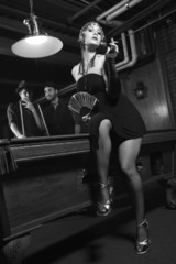 retro female in front of pool table with two  men in background.