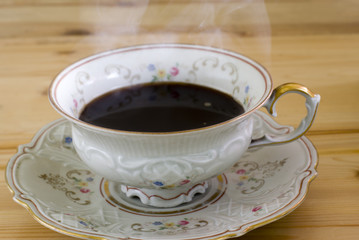 antique cup with hot steaming coffee