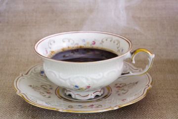 antique cup with hot steaming coffee