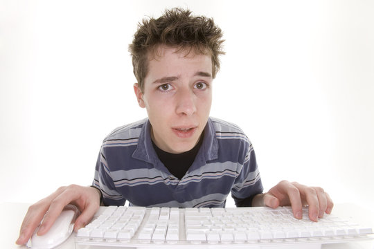confused teenage boy using computer