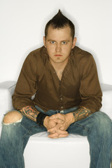 Caucasian man with tattoos and mohawk.