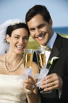 Bride and groom holding champagne glasses.