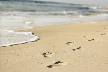 Coastline with footprints and waves. - 2985044