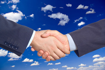 handshake against clouds