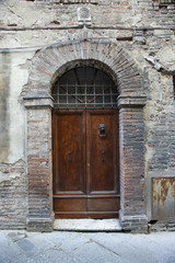 Fototapeta na wymiar Drewniane drzwi z bramy cegły.