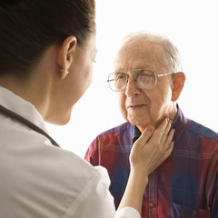 doctor checking an elderly man's pulse.