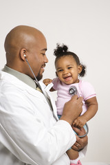 male pediatrician examining baby girl.