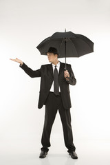 businessman holding umbrella with hand held out.