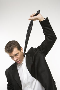 Man Pulling His Necktie As If To Choke Himself.