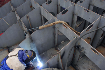 Fototapeta welder with protective mask welding metal and sparks obraz