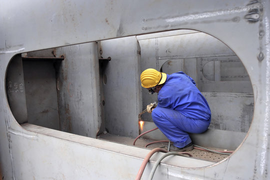 Welder with protective mask welding metal at Double bottom Cargo Ship