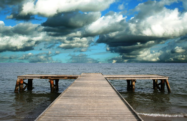 stormy clouds over wooden jetty